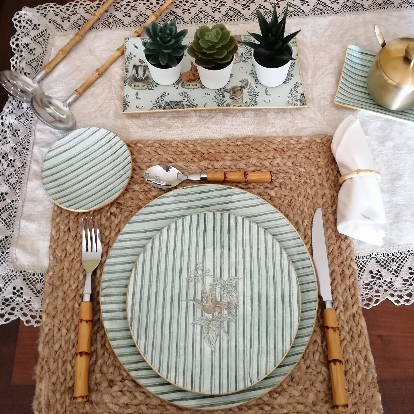 Detalle mesa con vajilla artesanal decoupage estampado rayas verde hoja. Incluye bajoplato 30 cm, plato postre 20 cm, y platito pan 10 cm.
