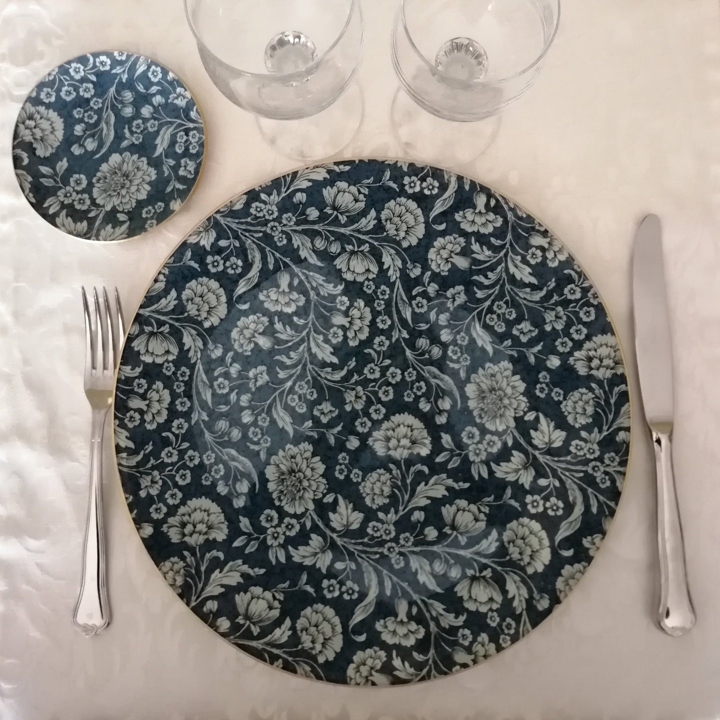 Conjunto de cristal decorado a mano con la técnica de decoupage. Incluye bajo plato redondo de 30 cm y platito de pan de 12 cm . El estampado incluye
motivos florales en tonos suaves y románticos, flores y hojas delicadas en beige. Fondo azul que realza el diseño
y bordes dorados que unifican el conjunto. Ideal si quieres una mesa elegante para ocasiones especiales o si quieres hacer un regalo perfecto para bodas o aniversarios.
✅ Decoración 100% artesanal