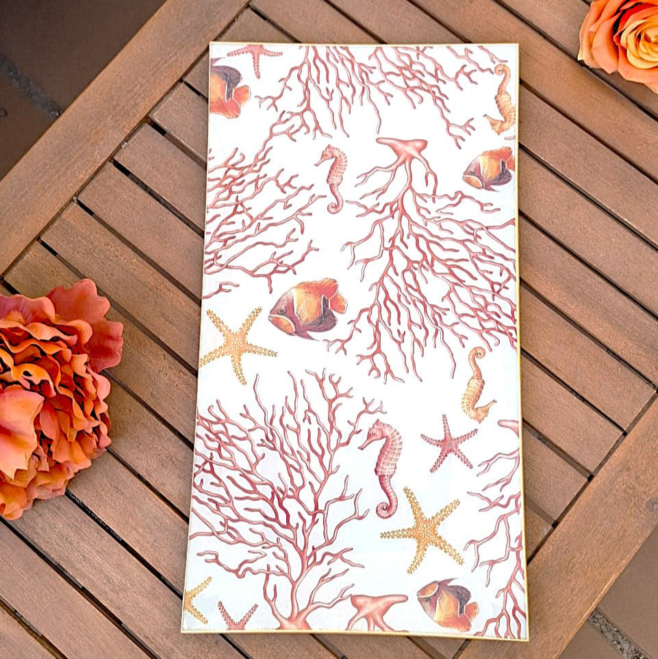 Bandeja de cristal decorada a mano con diseño marino de corales, estrellas de mar y peces tropicales en tonos rojos y naranjas".
Estilo muy veraniego y mediterráneo, perfecto para una mesa de exterior o para darle un toque costero a cualquier espacio.