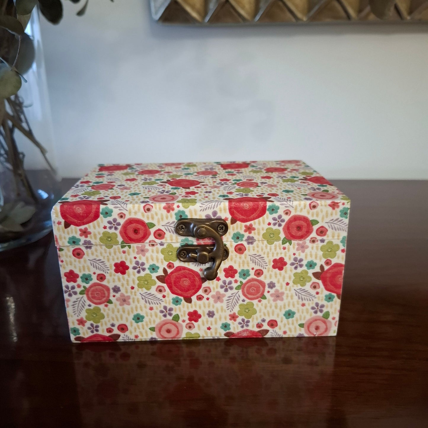 "Detalle caja madera decorativa hecha a mano decoupage artesanal" Estampado floral con rosas rojas prominentes, flores multicolores y hojas sobre fondo vintage beige.