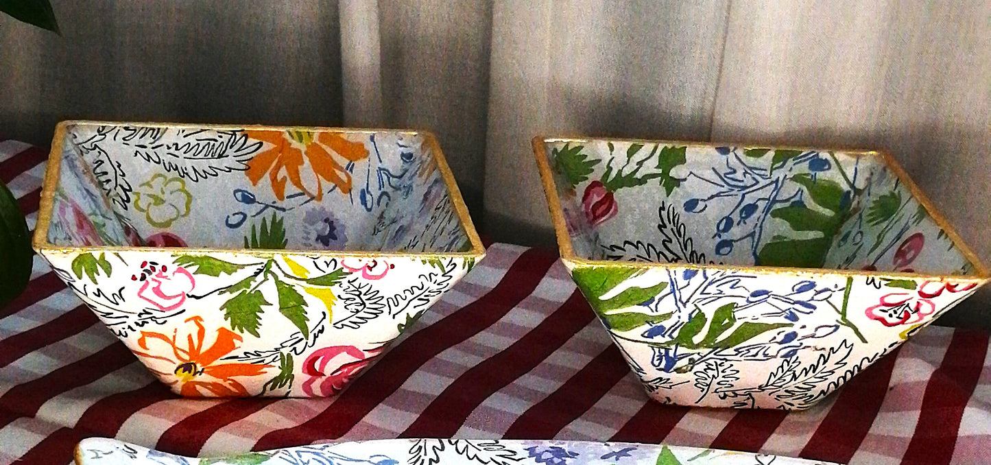 Cuenco de crista decorado a mano con estampado de flores en tonos vibrantes como el rosa, amarillo, lavanda, rojo y azul, acompañadas de hojas verdes y detalles botánicos. Los racimos de cerezas aportan un toque fresco y divertido.