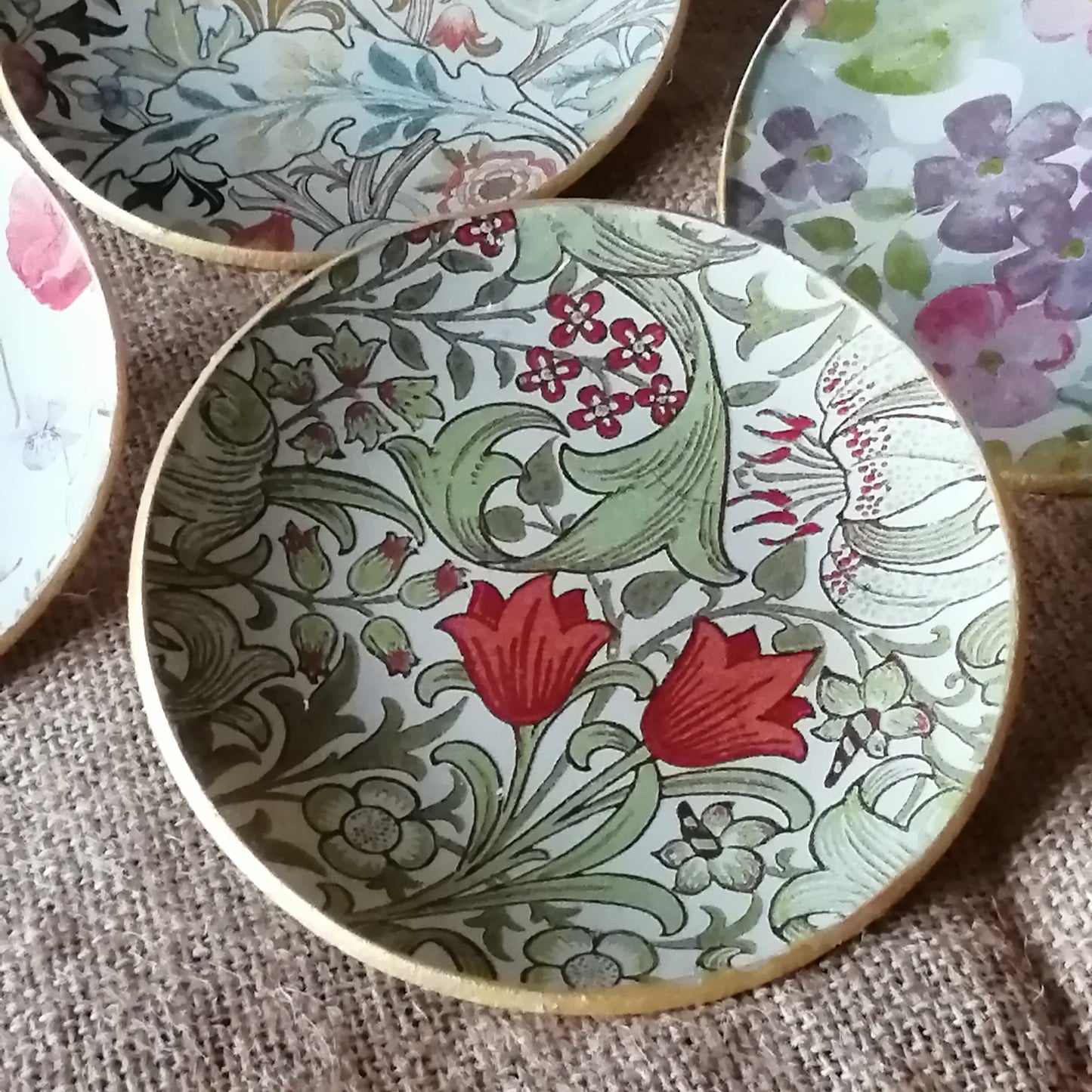 Platito decorado con estampado Golden Lily de William Morris en técnica decoupage. El diseño presenta: Flores corales vibrantes como elemento principal hojas y ramas en tonos verdes suaves pequeñas bayas rojas que añaden detalle fondo en tonos neutros que realza los colores y borde dorado que aporta sofisticación.
✅ Decoración 100% artesanal
✅ Perfecto para servir pan, bollería o aperitivos.
✅ Tamaño perfecto para uso individual.
✅ Estilo vintage romántico