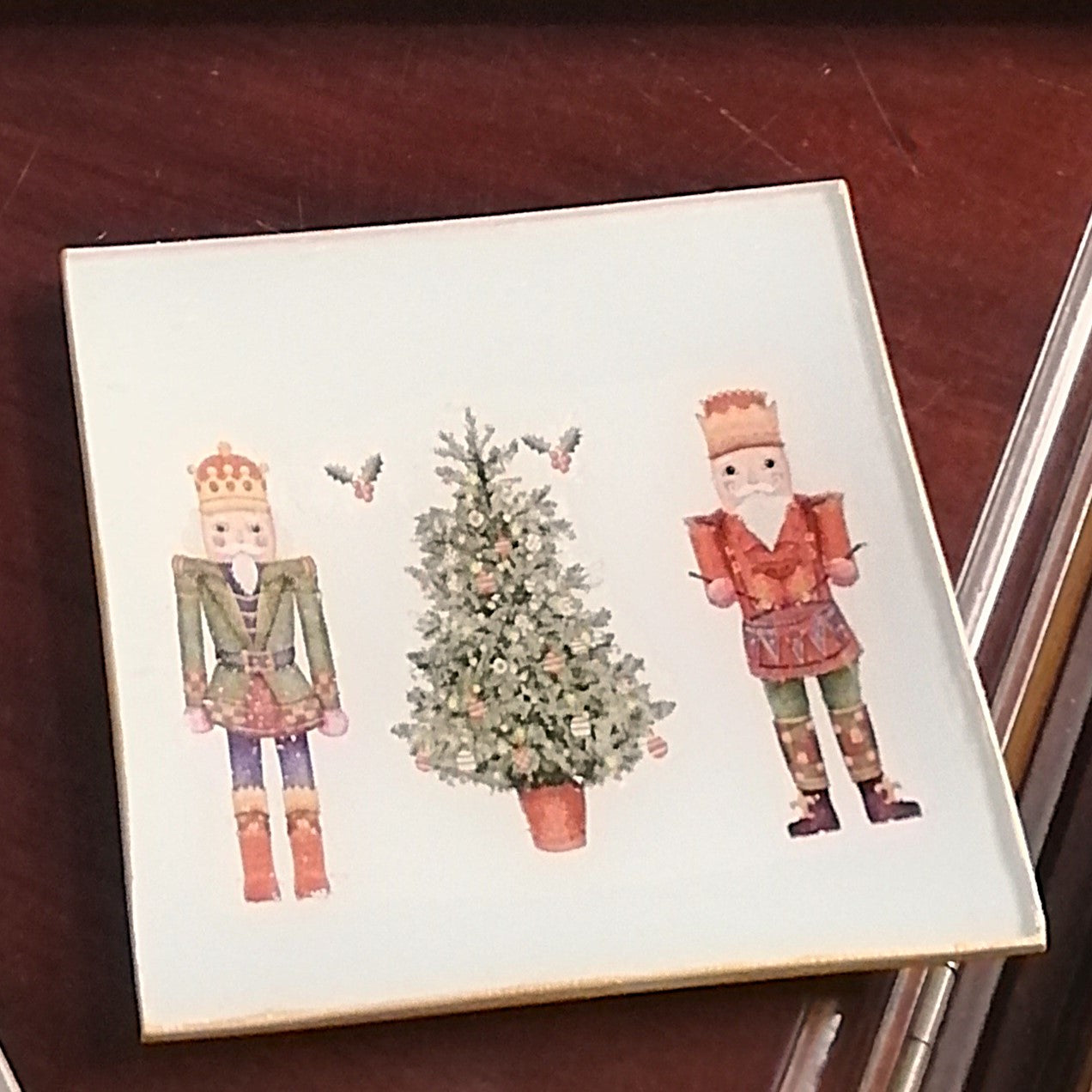 Platito cuadrado de 12x12 cm decorado a mano mediante decoupage con estampado de cascanueces y abeto de navidad.