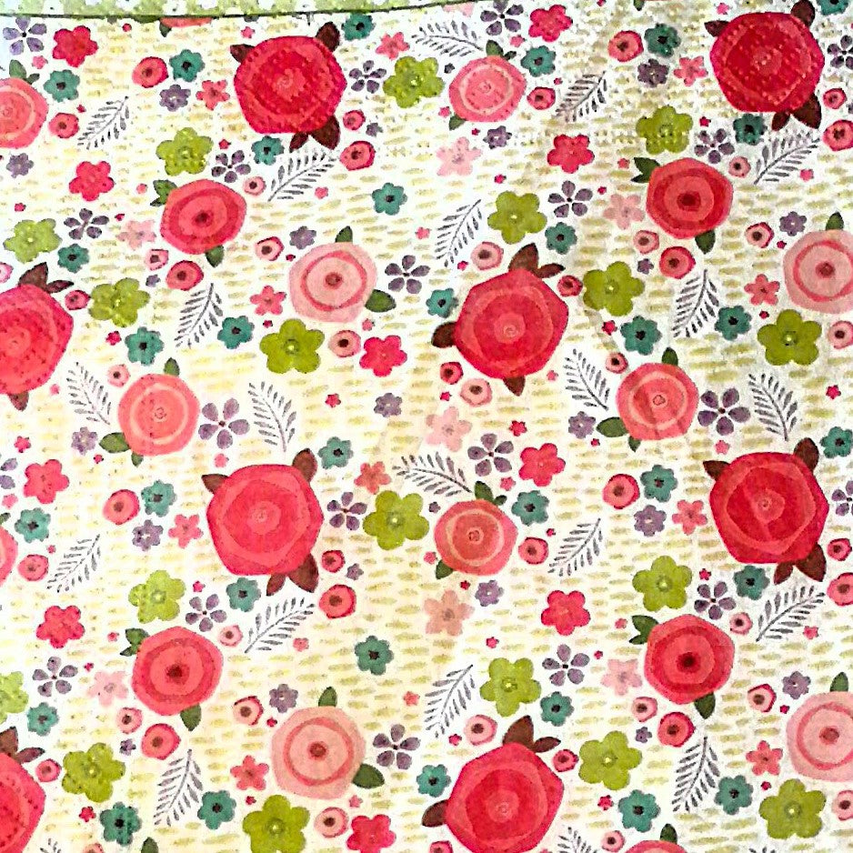 "Patrón floral con rosas rojas prominentes, flores multicolores y hojas sobre fondo vintage beige"