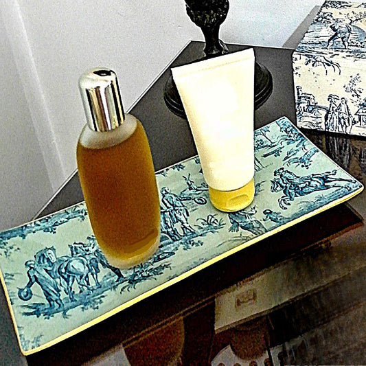 Bandeja decorativa realizada artesanalmente con estampado de escenas románticas de la vida campestre en fondo crema y motivos en azul.