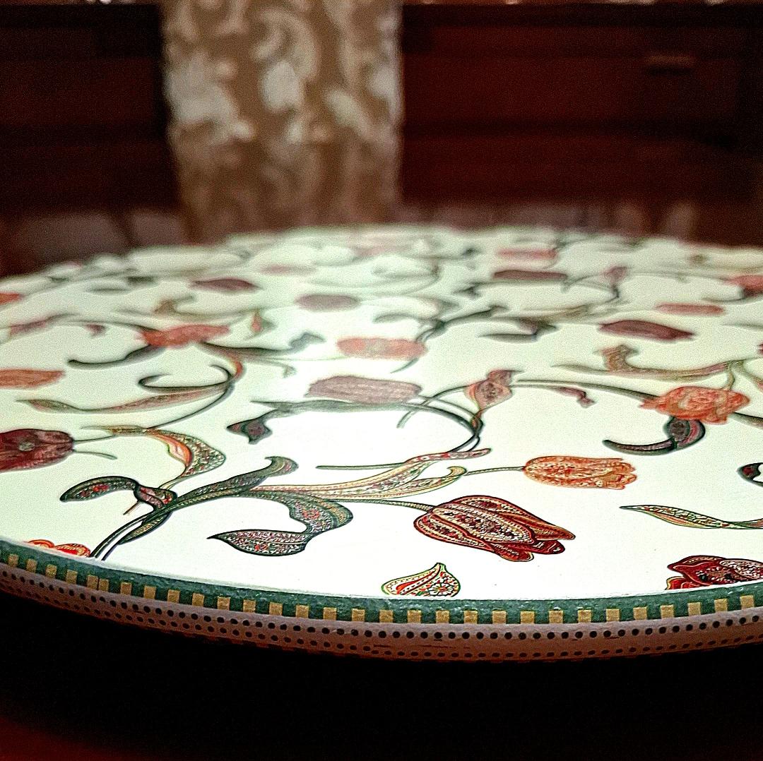 "Tabla giratoria artesanal con estampado de tulipanes estilo otomano en tonos terracota, marrones y coral sobre fondo crema, borde decorado con greca"