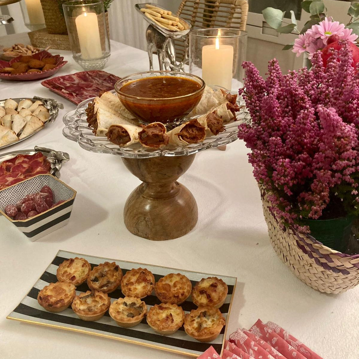 Detalle de mesa para celebración con bandejas y cuencos decorados a mano con estampado a rayas negras.