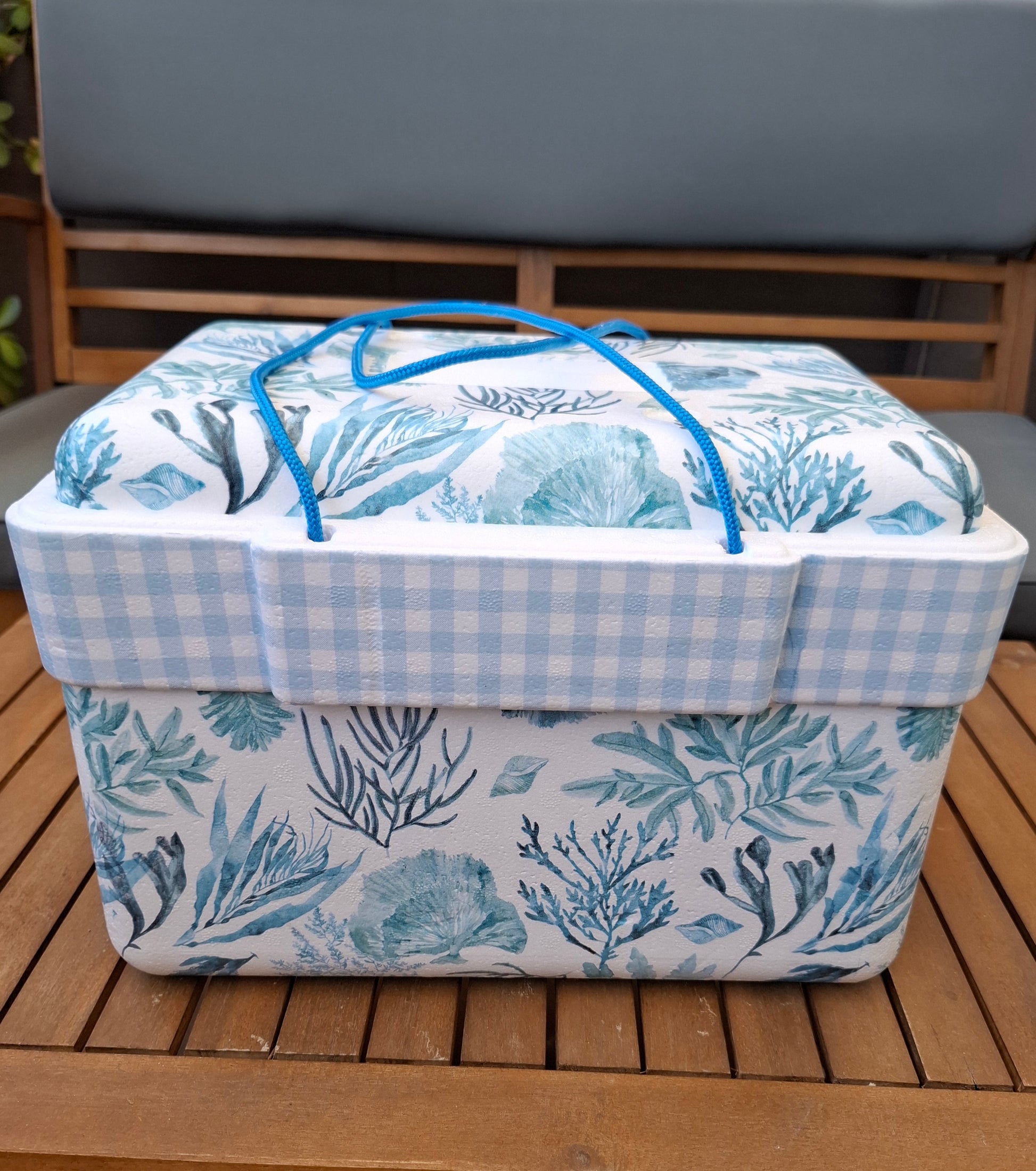 Nevera de corcho decorada a mano con estampados de algas marinas azules  sobre fondo blanco. Combinada con cuadrito vichy en celeste.
