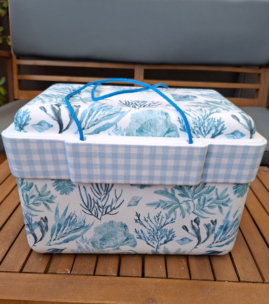Nevera de corcho decorada a mano con estampados de algas marinas azules  sobre fondo blanco. Combinada con cuadrito vichy en celeste.