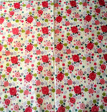 "Patrón floral con rosas rojas prominentes, flores multicolores y hojas sobre fondo vintage beige"