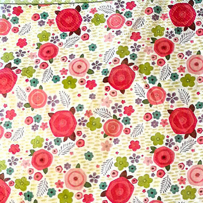 "Patrón floral con rosas rojas prominentes, flores multicolores y hojas sobre fondo vintage beige"