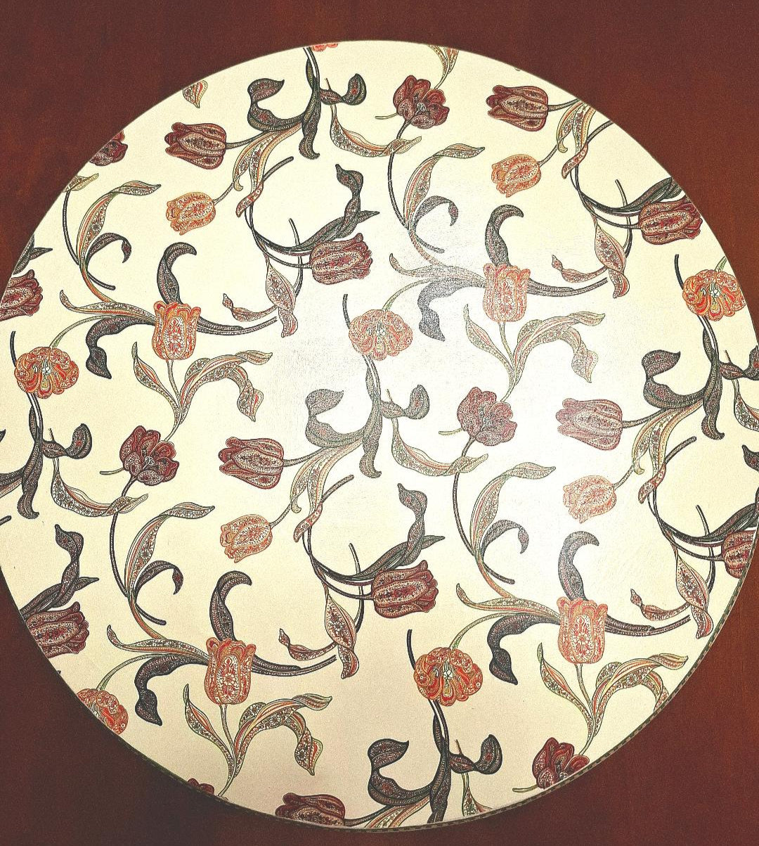"Tabla giratoria artesanal con estampado de tulipanes estilo otomano en tonos terracota, marrones y coral sobre fondo crema, borde decorado con greca"